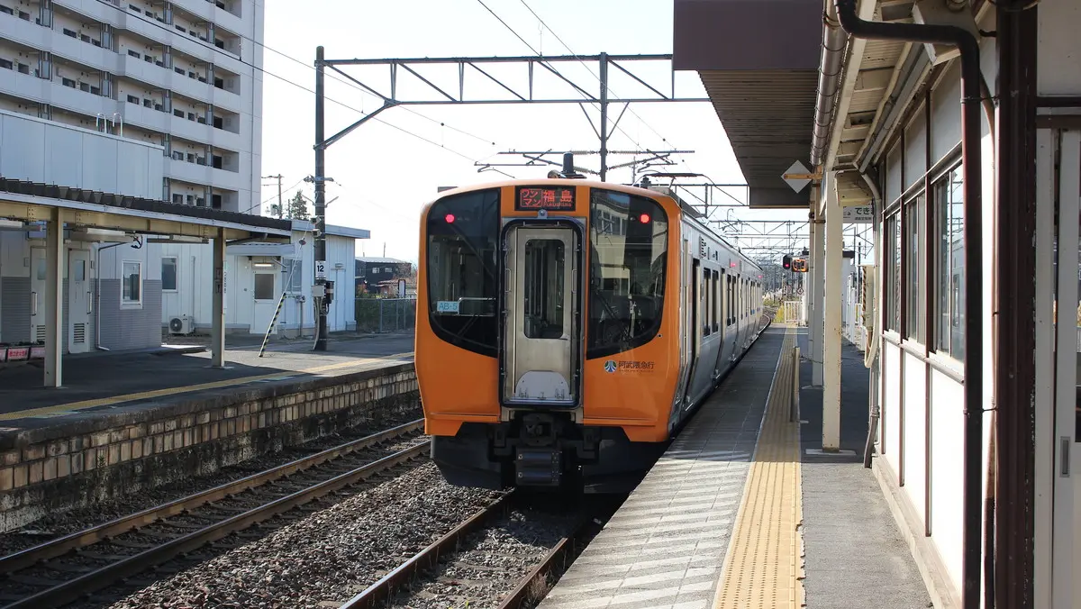 A yellow Abukuma Express AB900 series train parked at Tsukigi Station