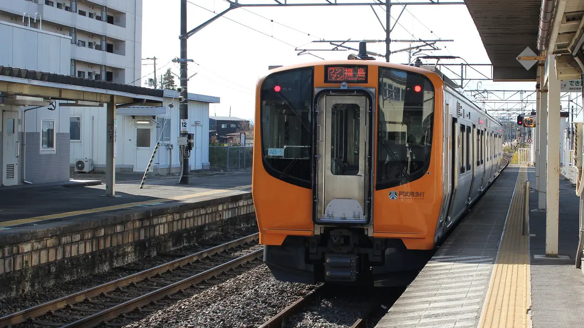 A yellow Abukuma Express AB900 series train parked at Tsukigi Station