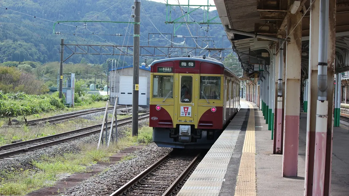 The Niigata-colored Myoko Haneuma Line E127 series train arrives at Myoko Kogen Station