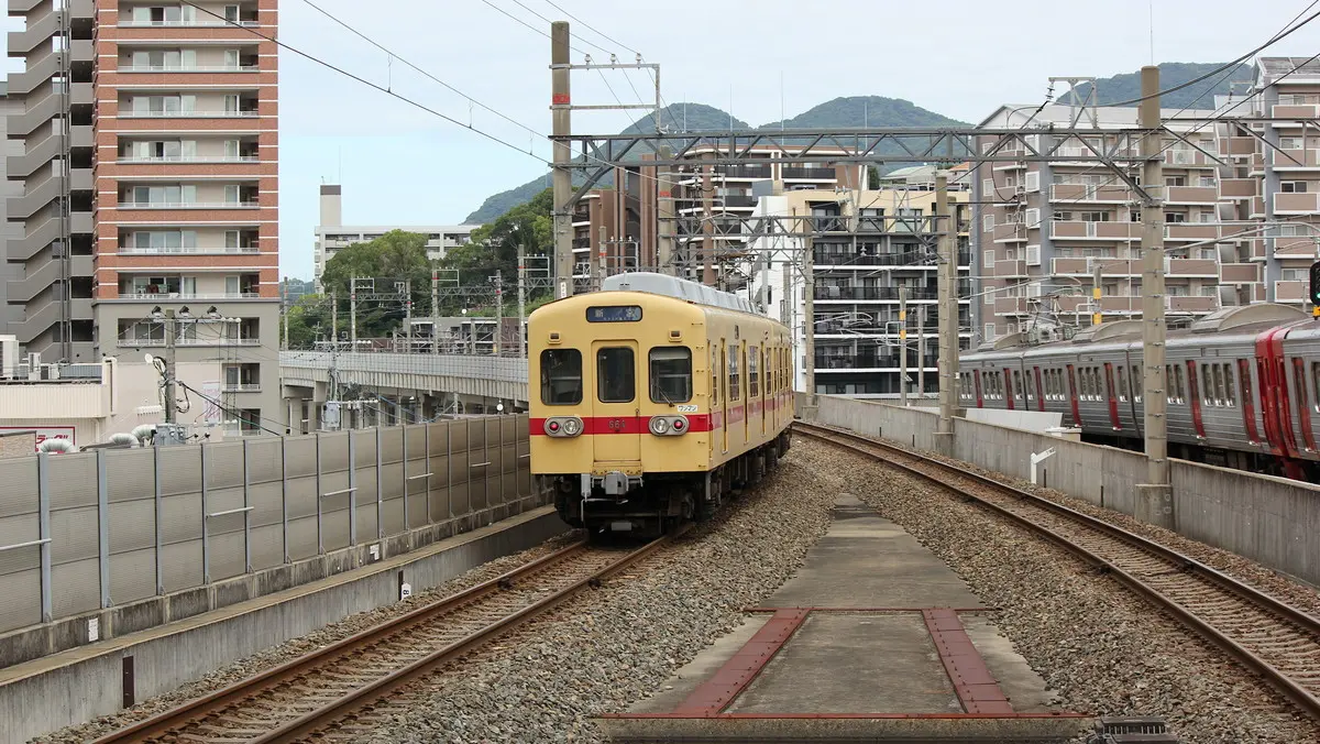 Nishitetsu Kaizuka Line 600 series train departing from Nippon Railway Chihaya Station