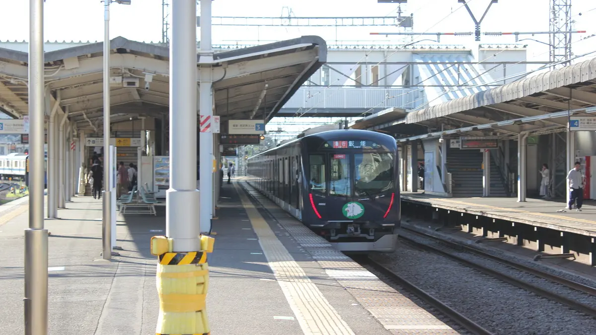 A wrapped Seibu Ikebukuro Line 30000 series train parked at Nishi-Tokorozawa Station