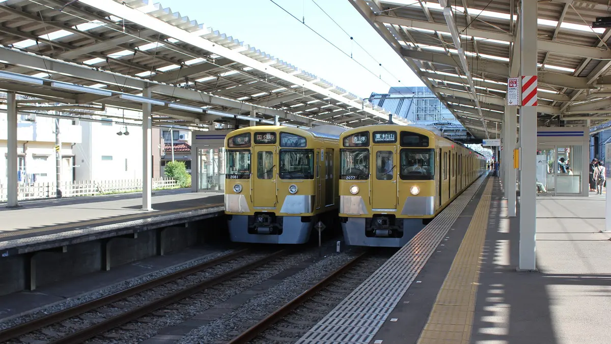 A Seibu Kokubunji Line 2000 Series train stops alongside a Seibu Haijima Line train at Ogawa Station
