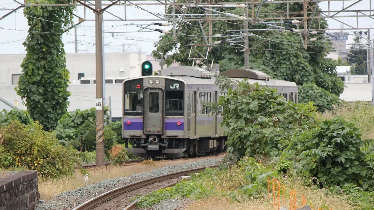 仙北町駅を出発した盛岡色の東北本線701系電車